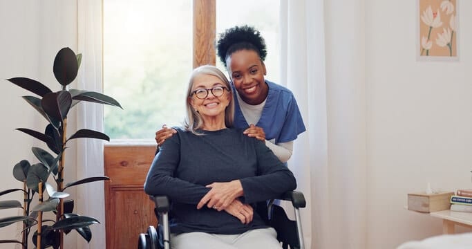 Caregiver smiling with senior client at home