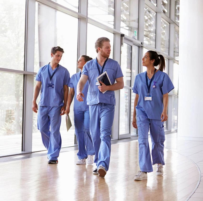 Healthcare professionals walking in hospital corridor.