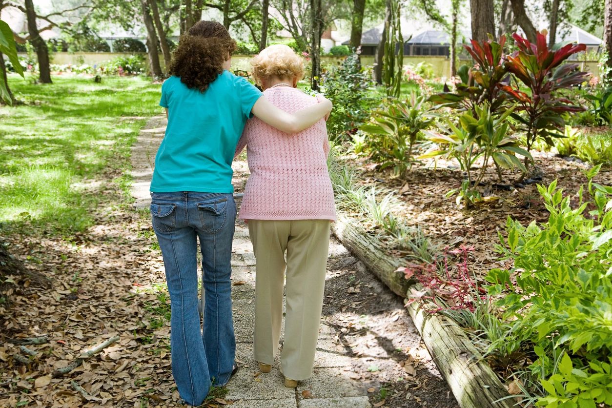 Two people walking together in a garden image.