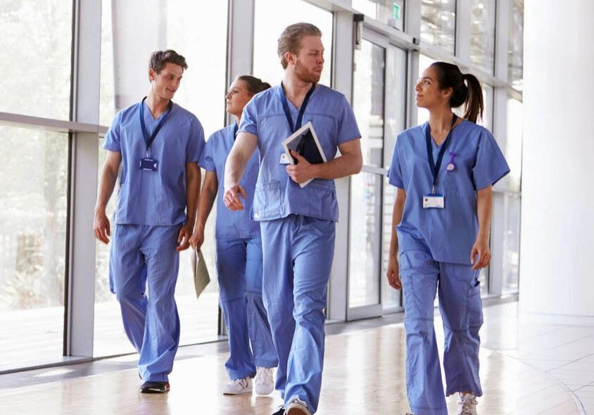 Healthcare professionals walking in hospital corridor.