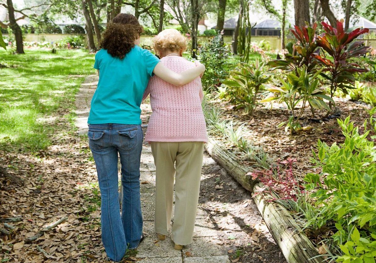 Two people walking together in a garden image.